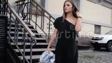 4k视频：穿着黑色小裙子的优雅年轻女子走在街上
