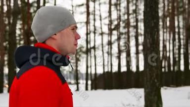 冬天，一个穿着红色夹克的年轻运动男子在新鲜空气中跑步。 慢慢