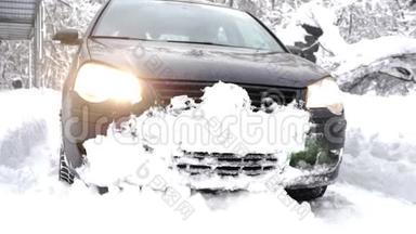 黑色<strong>的</strong>汽车在一片雪林中缓缓行驶，厚厚<strong>的茂密的</strong>树木和根在白雪覆盖<strong>的森林</strong>中。 远足