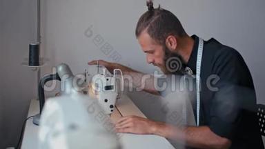 帅哥裁缝在自己的设计工作室缝制机器服装