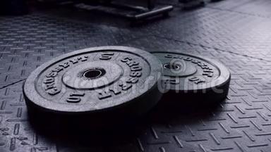 关闭健身房地板上的重物板，准备用于力量锻炼。 健身器材