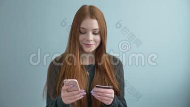 年轻漂亮的红发女孩在<strong>网上</strong>购物，<strong>网上</strong>银行使用智能手机购物，并提供信用