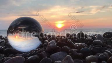 在石头上的<strong>水晶球</strong>里，阳光洒在水面上，沙滩上，风景中，充满了夕阳的倒影