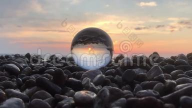 在石头上的水晶球里，阳光洒在水面上，沙滩上，风景中，充满了夕阳的倒影