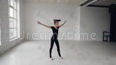 艺术体操：穿着黑色紧身衣的体操女孩在运动中用抱箍进行体操训练