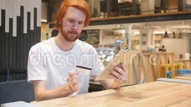 男人对成功的网上购物在咖啡馆，支付