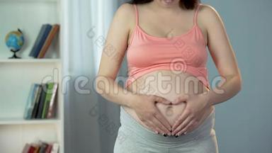 孕妇用手在大肚子上做心脏形状标志，爱宝宝