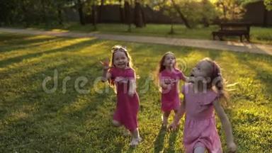 三个小女孩手牵着手在花园的绿草上奔跑，周围是空气吹泡器