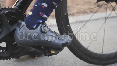 骑自行车的女孩在比赛训练前在脚踏车上夹路鞋。 链条和自行车关闭。 慢动作