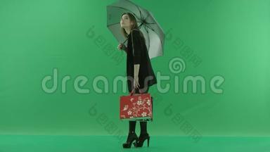 迷人的年轻女子<strong>伞下</strong>，彩色钥匙绿色背景