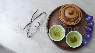 大理石桌上的绿茶和蝴蝶豌豆