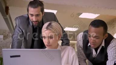 三个不同民族的工人在笔记本电脑上讨论思想、同事观念、沟通观念、商业观念