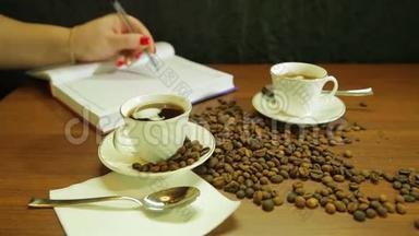 一杯浓咖啡，一杯<strong>咖啡豆散落</strong>在桌子上，一个女人写日记
