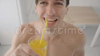 在炎热的夏天，年轻人在厨房里用管子喝着清爽的橘子汽水