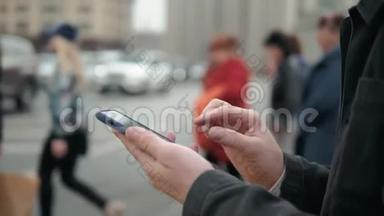男人在户外使用手机，关门，男人拿着手机走在街上，人们和汽车背景