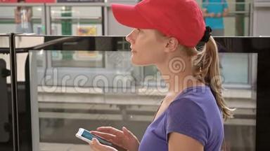 <strong>地铁地铁</strong>站上漂亮的年轻女子正在检查她的<strong>电话</strong>等待火车到达