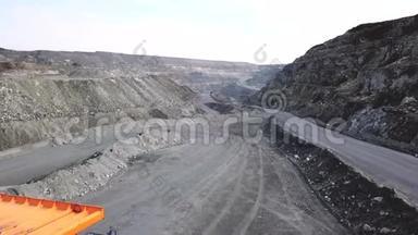 采石场自卸卡车俯视图.. 自卸卡车行驶在布满灰尘的露天采矿道路上。 重型运输