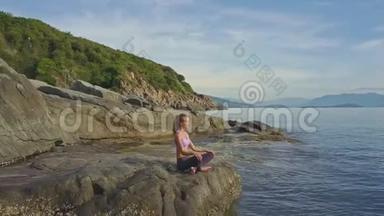 Flycam观景女孩坐瑜伽姿势对抗<strong>海潮</strong>到岩石