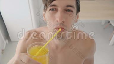 在炎热的夏天，年轻人在厨房里用管子喝着<strong>清爽</strong>的橘子汽水