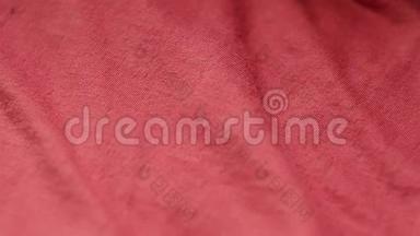 在一家纺织品商店里，一种光滑的红色混合涤纶棉织物的特写镜头。 把注意力集中起来。