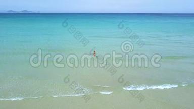鸟瞰女子在碧海中游泳.. 在蓝色天际线背景下的绿松石海中的无人机观看女人。