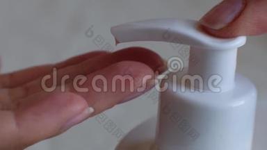浴室里干净的手里的奶油瓶上的手指按钮。 护肤，<strong>卫生健康</strong>的生活理念.. 关门