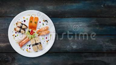 旋转生鱼片设置在白色的圆形盘子上，装饰有小花，日本菜，俯视.. 木制背景