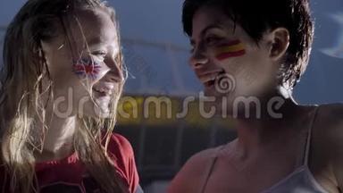 两个年轻的女孩，雨中的足球迷，英格兰和西班牙，微笑，笑着，球场背景50fps