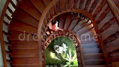 穿着粉红色裙子的女<strong>人下</strong>来，爬上一个绿色植物和喷泉的圆形<strong>楼梯</strong>。 4k