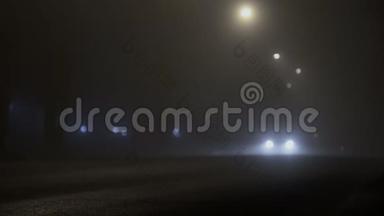 夜晚，有大灯的汽车在<strong>雾</strong>中行驶在道路上，由于<strong>雾霾</strong>，能见度低