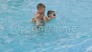 哥哥教一个<strong>弟弟</strong>戴着游泳眼镜在游泳池里游泳