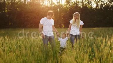 幸福的家庭，<strong>爸爸妈妈</strong>和儿子在情感上散步。 在新鲜空气中的绿色田野里奔跑和享受生活，蓝色