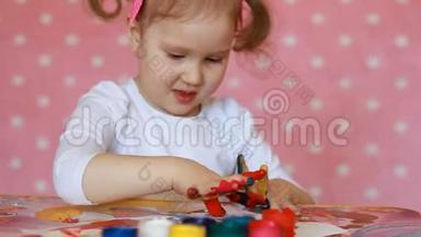 小女孩用刷子和油漆画画。 宝贝艺术。 古奇和油漆。
