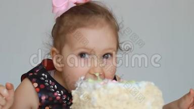 生日快乐。 一个可爱的小女孩吃一个脏脸和脏手的蛋糕。 一个在餐桌上吃甜点的孩子。 特写