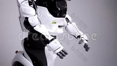 现代机器人技术。 白色现代机器人在一个明亮的工作室。 安卓舞，挥舞着手臂.. 示范