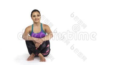 穿运动服的女人坐在地板上，空白的复印空间
