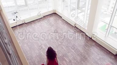 一个穿着红色连衣裙的女人赤脚沿着大顶<strong>楼房</strong>间走到窗户前。 她在调戏