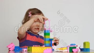 小女孩玩五颜<strong>六</strong>色的小积木的一个<strong>建设</strong>者。 孩子培养自己的思维能力.. 发展