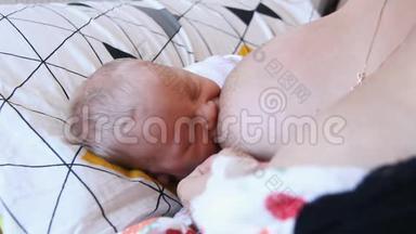 母亲抱着新生儿拥抱和母乳喂养她的婴儿，婴儿头部的特写，温柔和母亲的关怀。