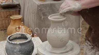艺术家陶工在他的车间创作了一件陶瓷陶器。 双手特写。