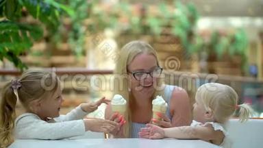 小女孩在大购物中心吃冰淇淋和一个喇叭。 家人在商场里吃冰淇淋。 家庭幸福。 可爱