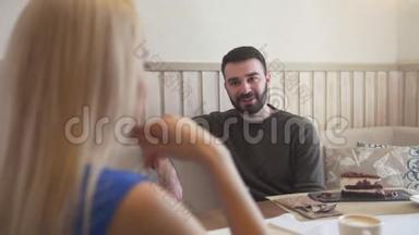 帅气的白种男人在女人面前边聊边享受咖啡厅的谈话