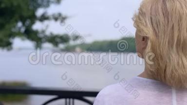 在城市公园欣赏河景的老妇人，<strong>展望未来</strong>，做梦