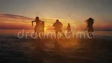 一群快乐的女孩在夕阳下的海滩上在<strong>水中</strong>奔跑和<strong>玩耍</strong>。 美丽快乐的青少年朋友玩得开心