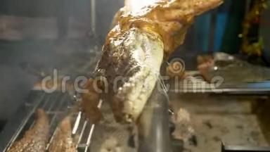 亚洲美食的概念。 一只小鳄鱼在篝火上烤着一口唾沫。