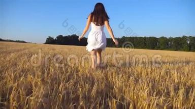 跟着小女孩沿着蓝天下的田野奔跑。 穿着裙子的女人在草地上慢跑，享受自由