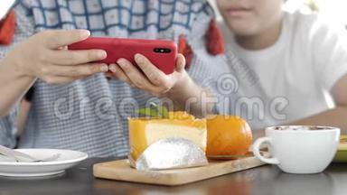 时髦的家庭母子在一家餐馆用手机相机制作食物照片。