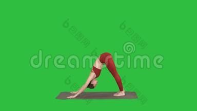 一位身穿红色运动服、做瑜伽或普拉提运动的漂亮年轻女子站在一个变异的纳塔拉扎纳