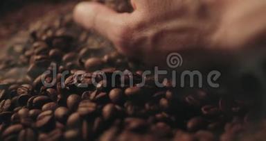 香喷喷的烤咖啡豆从人手里溅出来.. 慢运动中的芳香烟雾和棕色背景