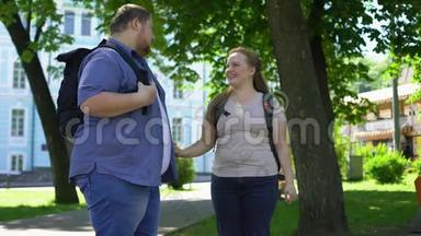 年轻的超重男女牵着手，在公园里滋滋作响，学生们喜欢